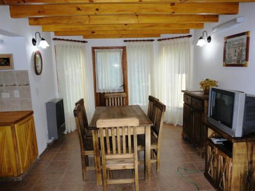 拉安戈斯图拉镇Cabañas Rukayen的一间带桌子和电视的用餐室