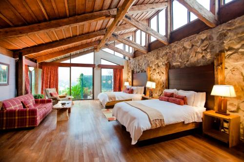 Vara Blanca波亚斯火山酒店的一间设有两张床和石墙的大卧室