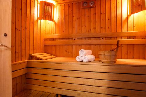 泰特文Family Hotel Teteven的一间桑拿浴室,配有两条滚毛巾和一桶水