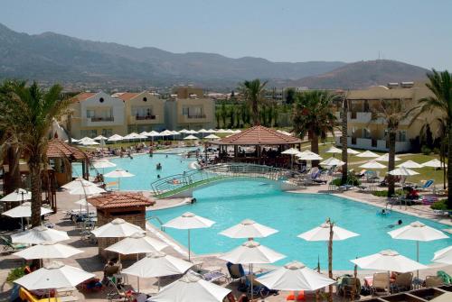 蒂加基索帕斯海滩酒店的一座带白色遮阳伞的大型游泳池,里面的人