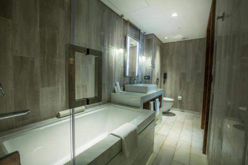 马尼拉Winford Resort and Casino Manila的带浴缸、盥洗盆和卫生间的浴室