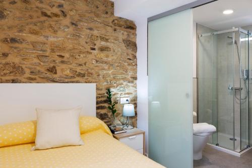 圣地亚哥－德孔波斯特拉Pensión Rua Nova的一间卧室设有一张床和石墙
