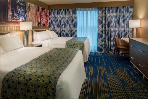 圣路易斯HoteLumiere at the Arch的酒店客房配有两张床和一张书桌