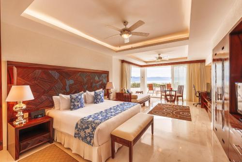巴亚尔塔港Grand Miramar All Luxury Suites & Residences的一间卧室设有一张床和一间客厅。