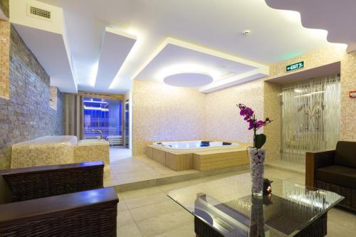贝尔格莱德萨沃伊城市酒店的一间带浴缸和桌子的客厅