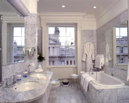 都柏林梅瑞恩酒店的一间带两个盥洗盆、浴缸和卫生间的浴室