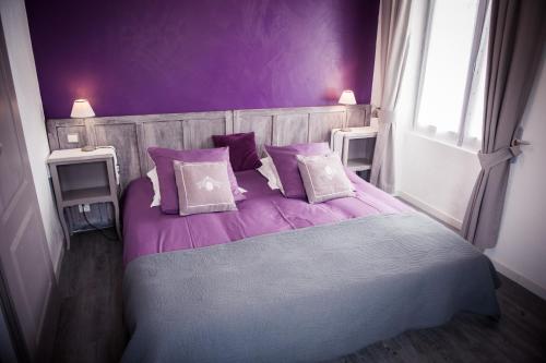 托德弗赫库姆勒多雷住宿加早餐旅馆的紫色卧室配有一张带紫色床单和枕头的床