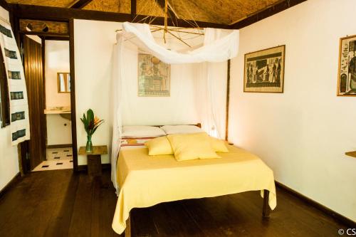 迪奥戈极酷旅馆的一间卧室配有一张黄色床单和天花板