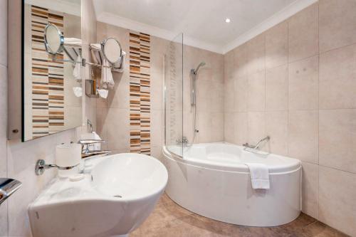 梅利哈Paradise Bay Resort的白色的浴室设有浴缸和水槽。