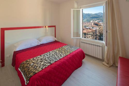 斯培西亚玛格丽塔酒店的一间卧室设有红色的床和大窗户