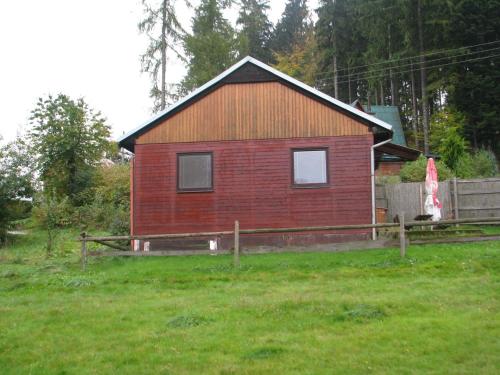 上贝奇瓦康普霍尔尼贝克瓦民宿的草场上的一座红色小房子