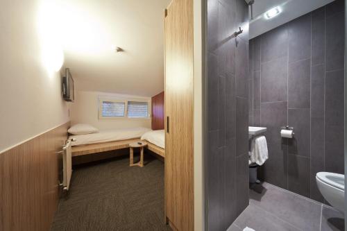 卢布尔雅那毕特中心酒店的小房间设有一张床和一间浴室