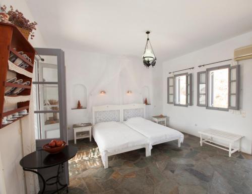 普拉提伊亚洛斯西弗诺斯奥斯提亚公寓的白色的卧室配有白色的床和一张桌子