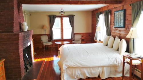 Rindge伍德邦德酒店的卧室配有白色的床和壁炉