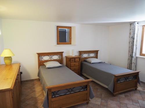 马诺斯克campagne de pimayon的一间卧室配有两张床、一张桌子和一面镜子