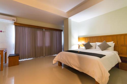 库塔库塔AB酒店的一间卧室设有一张大床和一个大窗户