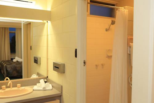 莱克斯恩特伦斯Ocean Views Motel Lakes Entrance的一间带水槽、镜子和淋浴的浴室