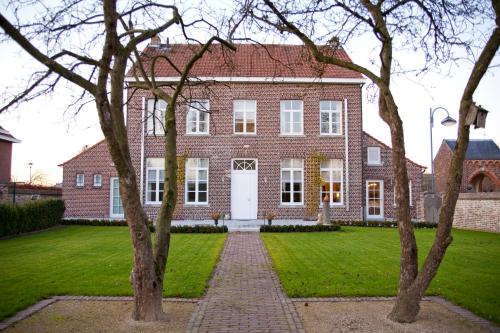 Grote-BrogelDe Pastory的一座大型红砖房子,设有白色门