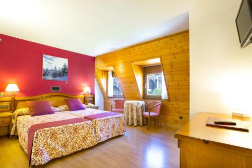 维耶拉Hotel Eth Solan & SPA的一间卧室配有一张床、一张桌子和一张书桌