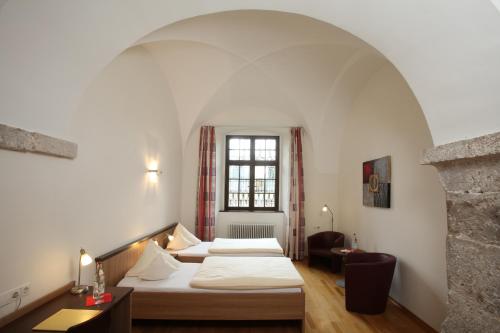 ObermarchtalKloster Obermarchtal的酒店客房设有两张床和窗户。