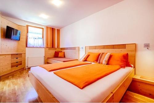 约伊斯Winzerhof Agerlhof的一间卧室配有一张带橙色毯子的大床