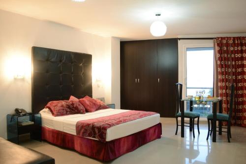 卡利卡里玛真实酒店的一间卧室配有一张带黑色床头板和一张桌子的床。