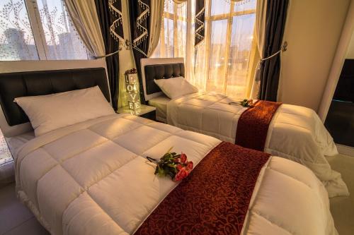 MawāliḩAl Mawaleh Furnished Flats & Rooms的一间卧室设有两张床和窗户。