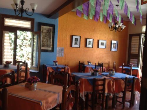 瓦哈卡市Hotel Maela的一间设有桌椅和蓝色墙壁的餐厅