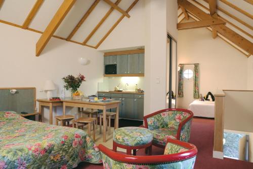 阿瓦隆Cit'Hotel Avallon Vauban的配有一张床和一张桌子及椅子的房间