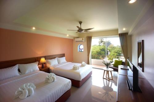 柴老海滩布兰卡别墅餐厅酒店 的酒店客房设有两张床和一个阳台。
