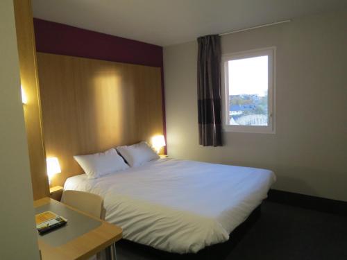 伊沃托B&B HOTEL Yvetot的酒店客房设有床和窗户。