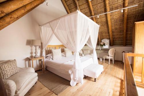 弗朗斯胡克克莱因瓦特瓦尔河滨旅馆的一间卧室配有一张带天蓬的白色床