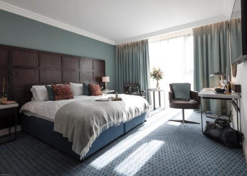 剑桥Clayton Hotel Cambridge的一间卧室配有一张大床和一张书桌