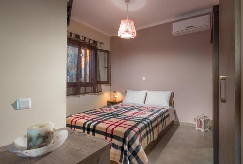 SagiadaMargarita Rooms Sagiada的一间卧室配有带条纹毯子的床