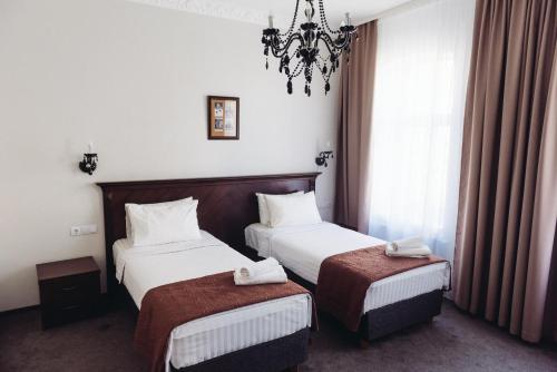 陶格夫匹尔斯Biplan City的酒店客房设有两张床和吊灯。