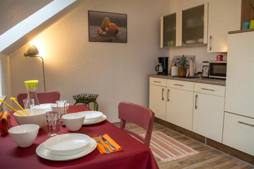 巴特萨尔茨乌夫伦Eulennest-OWL的厨房以及带红色桌椅的用餐室。