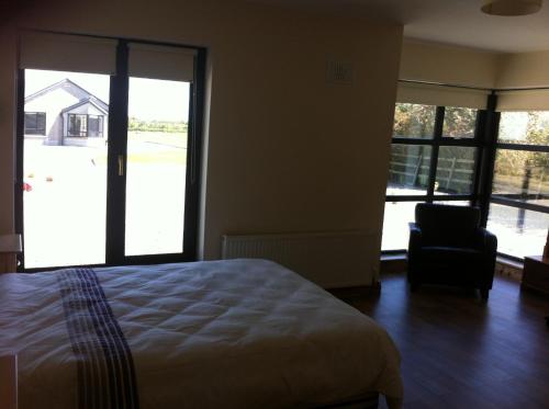 基尔莫尔码头Kilmore Quay Castleview 1 - 5 Bedroom House的一间卧室配有一张床、一把椅子和窗户。