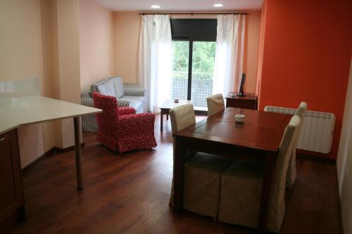 塔雷加Apartaments Tarrega Lagranja的一间带桌椅的客厅和一间用餐室