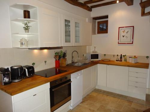 皮利尼蒙特拉谢The Mews的厨房配有白色橱柜和木制台面