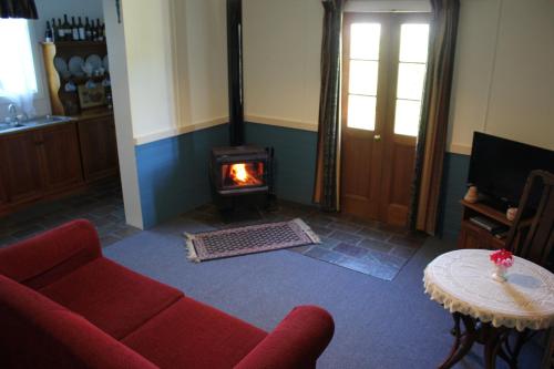 库纳瓦拉库纳瓦拉皮鲁斯小屋民宿的客厅设有红色的沙发和壁炉