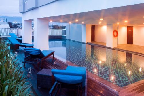 帕卢贝斯特韦斯特加可可帕卢酒店 的一座带蓝色椅子的游泳池,位于大楼旁