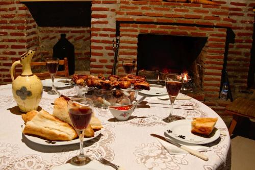 西格纳吉Guest House Aisi的一张桌子,上面放着一盘食物和酒杯