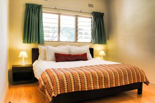 利文斯顿Victoria Apartments的一间卧室设有一张大床和窗户