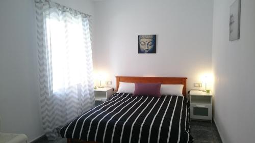 阿利坎特Apartment Periañez的一间卧室配有一张带黑白条纹毯子的床