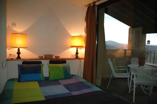 MontsonisLoft con chimenea y terraza con vistas的一间卧室配有一张床,阳台配有桌子