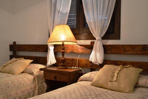 MontsonisCasa Anina的一间卧室设有两张床、一盏灯和一扇窗户。