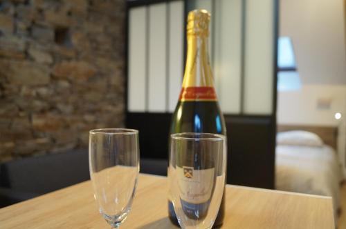 康卡勒L'atelier的一瓶香槟和一张桌子上的两杯酒