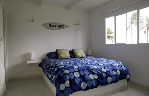 圣安德烈斯South End Villas的一间卧室配有一张带蓝色和白色棉被的床