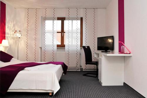 弗里德贝格布鲁诺酒店的酒店客房配有一张床、一张书桌和一台电视。