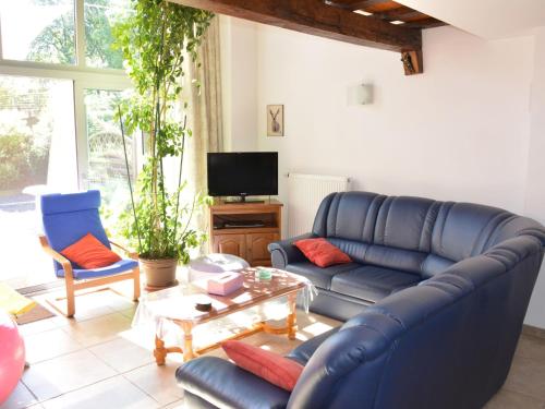 RadelangeRural lodging located in the small village of Radelange 100 Nature的客厅配有蓝色的沙发和两把椅子
